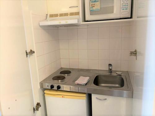 a small kitchen with a sink and a microwave at KozyGuru / Haymarket SYD / Cozy Warm / 1 Bed APT / NHA317-546B in Sydney
