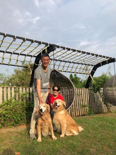 a man and a woman standing next to two dogs at 墾丁勿忘我城堡莊園 in Hengchun
