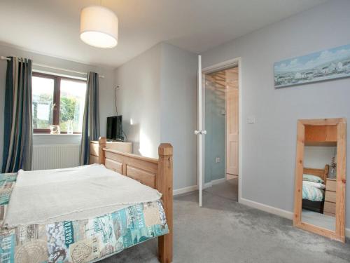 a bedroom with a bed and a window and a mirror at The Seashell in Dawlish Warren