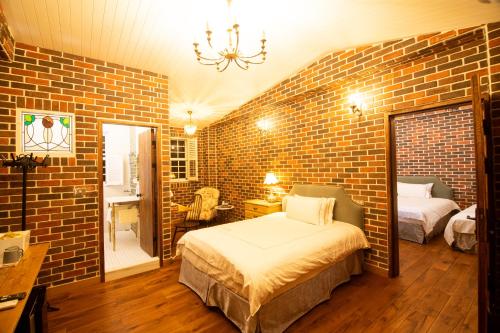 a brick walled bedroom with a bed and a mirror at 墾丁勿忘我城堡莊園 in Hengchun