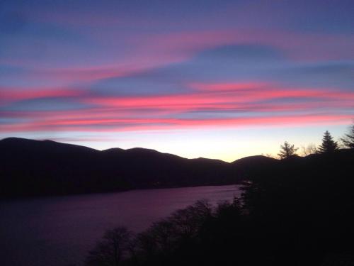 a sunset over a body of water with mountains at B&B Lago Maggiore in Cannobio