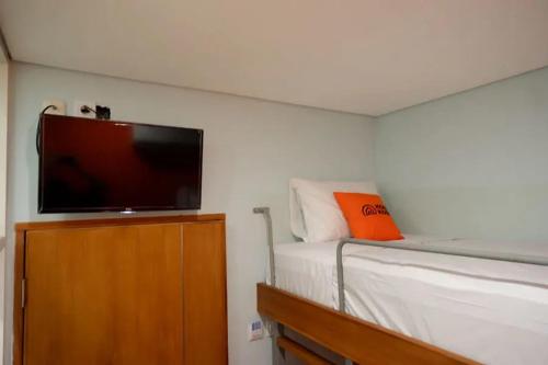 a bedroom with a bed and a flat screen tv at KoolKost @ Inep Kayu Jebres in Solo
