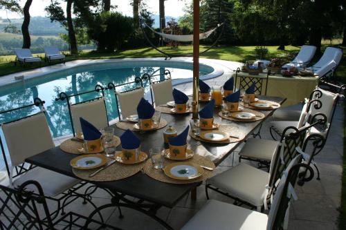 une table avec des assiettes de nourriture à côté d'une piscine dans l'établissement Domaine du Bouloy, à Druyes-les-Belles-Fontaines
