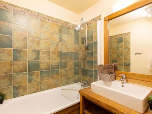 une salle de bain avec un lavabo, une baignoire et une douche dans l'établissement Appartement centre-ville Saint-Lary-Soulan avec piscine, sauna et parking - FR-1-296-442, à Saint-Lary-Soulan