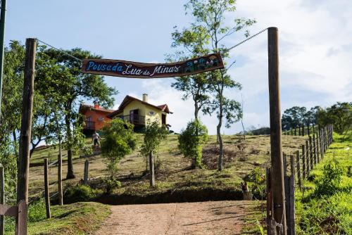 a sign for a house in a field at Pousada Lua de Minas in Visconde De Maua