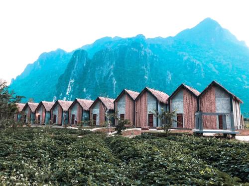 una fila de casas frente a una montaña en Vangvieng Angsavanh Resort, en Vang Vieng