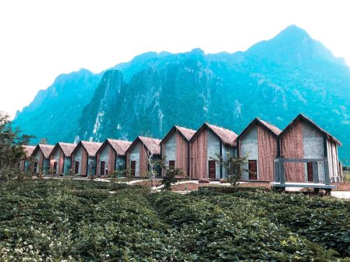 a row of houses in front of a mountain at Vangvieng Angsavanh Resort in Vang Vieng