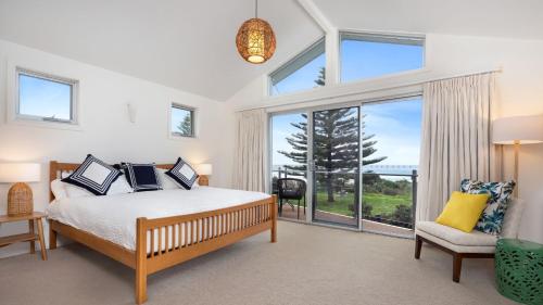- une chambre avec un lit et une grande fenêtre dans l'établissement Jones Waterfront Beach Escape, à Kiama Downs