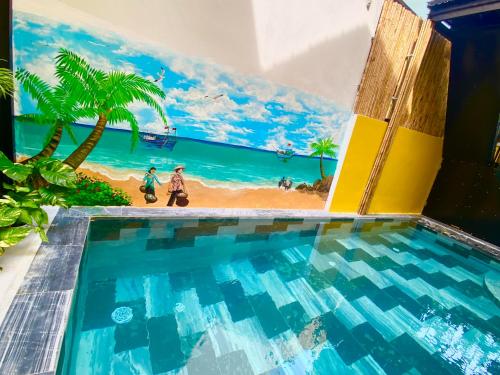 einen Pool mit einem Wandbild eines Strandes und Palmen in der Unterkunft An Bang Sea Adventure Homestay Hoi An in Hoi An