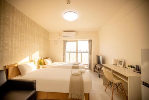 a hotel room with two beds and a desk at RTi天王寺 in Osaka