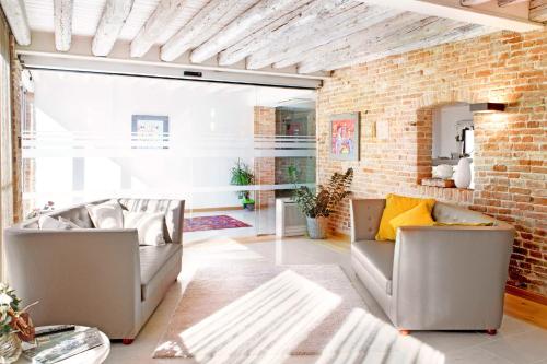 a living room with two couches and a brick wall at Do Ciacole In Relais in Mira