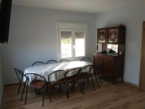 comedor con mesa, sillas y ventana en Casa Chao, en Estopiñán