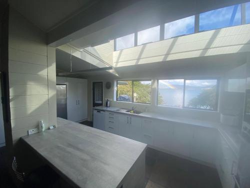 a large kitchen with white cabinets and a large window at The Willows in Rotorua