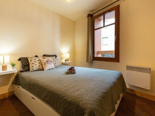 une chambre avec un grand lit et une fenêtre dans l'établissement Appartement centre-ville Saint-Lary-Soulan avec piscine, sauna et parking - FR-1-296-442, à Saint-Lary-Soulan