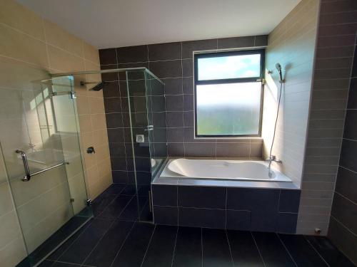 a bathroom with a bath tub and a window at ●STG12●3-Storey●Private House●2step Access Garden● in Bayan Lepas