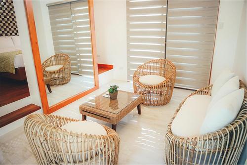 a room with wicker chairs and a table and a mirror at Estancia de lorenzo in San Mateo