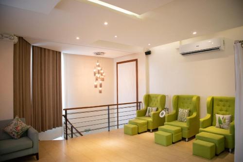 a waiting room with green chairs and a chandelier at Estancia de lorenzo in San Mateo