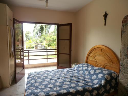a bedroom with a bed and a door to a balcony at Casa Riviera de São Lourenço in Riviera de São Lourenço