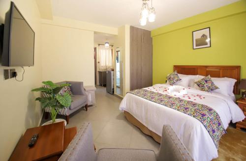une chambre avec un lit, une télévision et un canapé dans l'établissement Lantern Serviced Apartments, à Nairobi