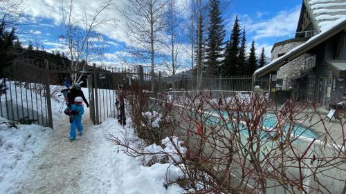 a man and a child walking through the snow at Aspens on the Mountain Ski In Out in Whistler