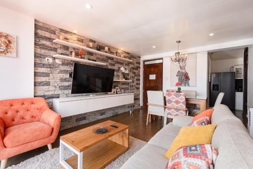 a living room with a couch and a tv at Town Center Apartments in Urubamba