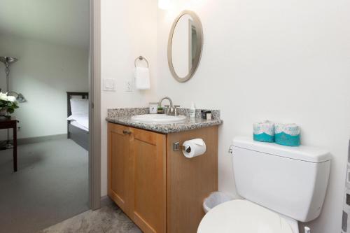 a bathroom with a toilet and a sink and a mirror at RIVERWALK SEASIDE- Walk to beach, One level home, pet friendly in Seaside