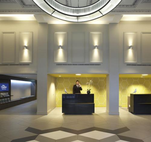 a man standing at a podium in a lobby at Citadines Trafalgar Square London in London