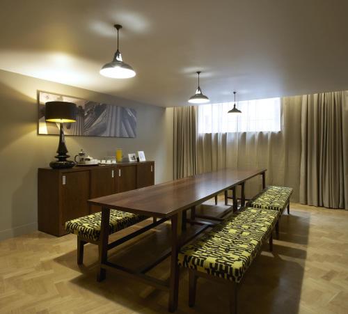 a dining room with a table and two benches at Citadines Trafalgar Square London in London