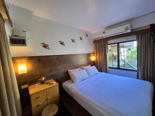 a bedroom with a white bed and a window at Baan Rachaya in Chiang Mai