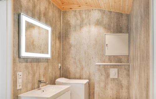 a bathroom with a sink and a toilet and a mirror at Nice Home In Ornes With House Sea View in Ornes