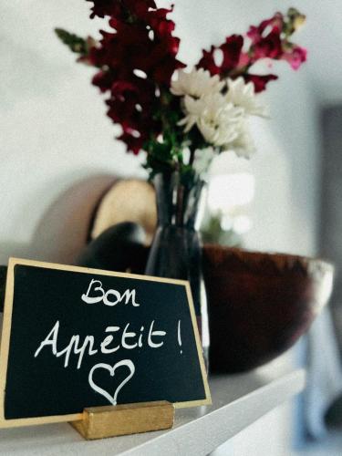a vase with flowers and a sign on a table at Villa Kazabona Saint-Pierre centre - Chambres d'hôte in Saint-Pierre