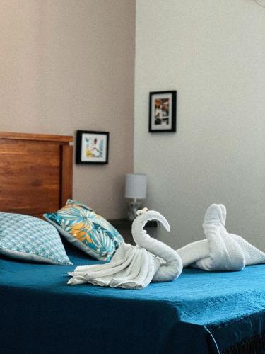 a bed with two stuffed swans on it at Villa Kazabona Saint-Pierre centre - Chambres d'hôte in Saint-Pierre