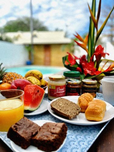 a table with a plate of food with bread and fruit at Villa Kazabona Saint-Pierre centre - Chambres d'hôte in Saint-Pierre