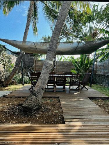 a hammock and benches on a deck with a tree at Villa Kazabona Saint-Pierre centre - Chambres d'hôte in Saint-Pierre