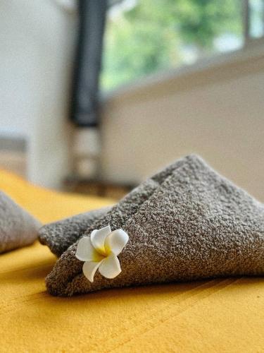 a flower on top of two towels on a table at Villa KaZabona Saint-Pierre - Chambres d'hôte in Saint-Pierre