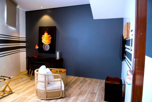 a room with a blue wall and a table and chairs at UNWND Boutique Hotel Dumaguete in Dumaguete