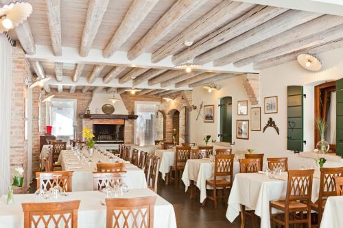 a restaurant with white tables and chairs and a fireplace at Do Ciacole In Relais in Mira
