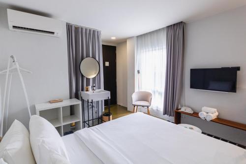 曼谷的住宿－Chocolate box mint - SHA Plus，酒店客房配有白色的床和镜子