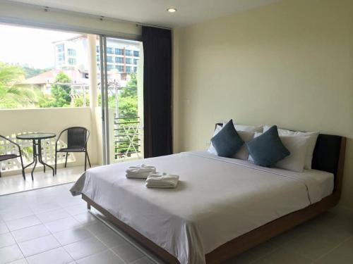 a bedroom with a large bed and a balcony at Glitter House in Phuket