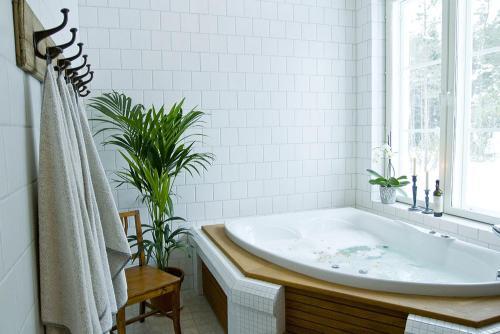 a white bathroom with a tub and a window at Westerby Gård in Inkoo