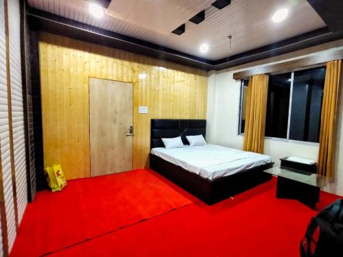 1 dormitorio con 1 cama y alfombra roja en Jaldapara Riverhine by StayApart, en Uttar Simlabari