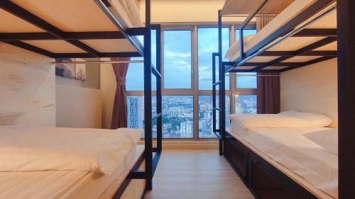 2 Etagenbetten in einem Zimmer mit einem großen Fenster in der Unterkunft La Vista @ Regalia Residence in Kuala Lumpur