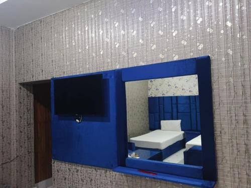 a mirror in a room with a bed and a tv at Hotel Sereena residence in Multan