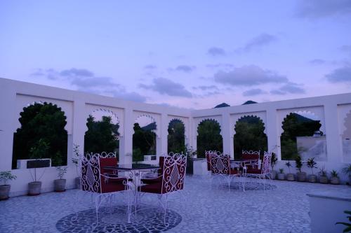 a patio with tables and chairs in a building at Emperor Palace A Heritage villa in Udaipur