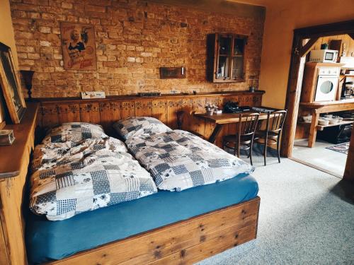 een bed in een kamer met een bakstenen muur bij Vintage-Design Ferienwohnung Viktoria in Bad Klosterlausnitz