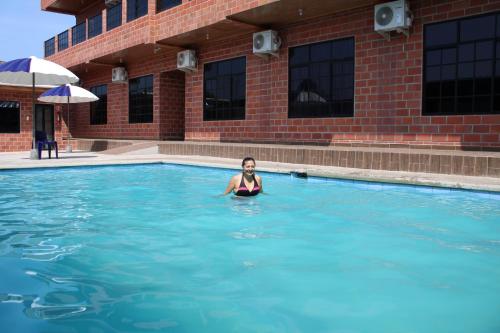 een vrouw in het water in een zwembad bij Hotel International in Pedernales