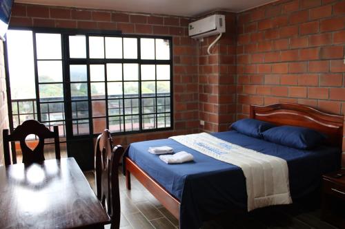 een slaapkamer met een bed en een tafel en ramen bij Hotel International in Pedernales