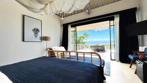 a bedroom with a bed and a view of the ocean at Villa Paradise Uluwatu in Ungasan