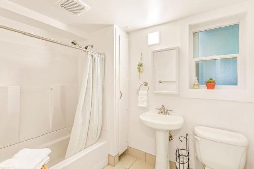 uma casa de banho branca com um lavatório e um WC em NEW: Bright, Peaceful Retreat in Iconic Seattle Neighborhood em Seattle