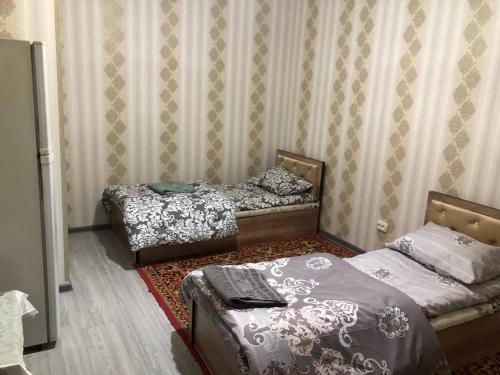 a room with two beds and a couch in it at Дом Отель Бадамзар in Tashkent